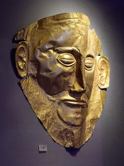 Pohřební maska z Mykén, hrob V, hrobový okruh A. Zlatý plech. Schliemann se domníval, že je to maska Agamemnona, ale je starší, z 16. století před n. l. Národní archeologické muzeum v Athénách, NAMA 624. Kredit: Zde, Wikimedia Commons. Licence CC 4.0.