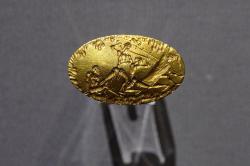 Zlatý prsten z hrobu IV (hrobový okruh A) v Mykénách, s bojovou scénou. Národní archeologické muzeum v Athénách. Kredit: Zde, Wikimedia Commons. Licence CC 4.0.