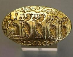 Zlatý prsten z Tíryntu. 15. století před n. l. Sedící bohyně přijímá procesí mořských koníků. Národní archeologické muzeum v Aténách, NAMA 6208. Kredit: Zde, Wikimedia Commons. Licence CC 4.0.