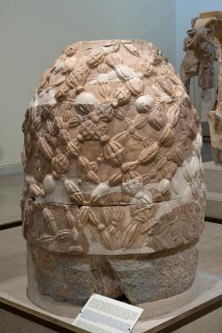 Kamenný omfalos, který byl nalezen nedaleko od Apollónova chrámu v Delfách. Pravděpodobně reprodukuje tvar omfalu, který stával v adytu chrámu, tedy ve věštírně. Archeologické muzeum v Delfách, 8140. Kredit: Zde, Wikimedia Commons. Licence CC 4.0.