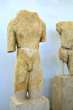 Kúros z Naxu, nalezený na Délu, naxijský mramor, torzo. Podle Zafiropoulou 650-600 před n. l., podle popisky 600-550 před n. l. Museum na Délu, A 4045. (Vpravo stojí kúros A 4085). Kredit: Zde, Wikimedia Commons. Licence CC 4.0.