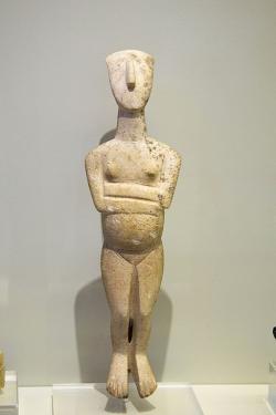 Stojící těhotná žena, mramor, 23 cm. Koumasa na Krétě, raná doba bronzová, 2700 až 2400 před n. l. Idol importovaný z Kyklad, varieta Spedos, kultura Keros-Syros. Archeologické muzeum v Irakliu, Γ122. Kredit: Zde, Wikimedia Commons. Licence CC 4.0.