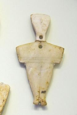 Kykladský idol s otvory, které ukazují na opravu ve staré době. Mramor, výška 11 cm. Koumasa nebo Ag. Onoufrios na Krétě. Raná doba bronzová, 2600 až 2300 před n. l. Archeologické muzeum v Irakliu, 125. Kredit: Zde, Wikimedia Commons. Licence CC 4.0.