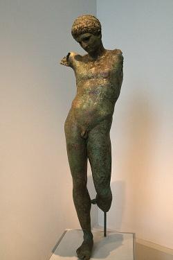 Bronzová socha mladíka, asi představuje atleta. Klasicizující práce. Neznámé místo nálezu, z moře. NAMA 26087. Kredit: Zde, Wikimedia Commons. Licence CC 4.0. Bronzová socha mladíka, asi představuje atleta. Klasicizující práce. Neznámé místo nálezu, z moře. NAMA 26087. Kredit: Zde, Wikimedia Commons. Licence CC 4.0.
