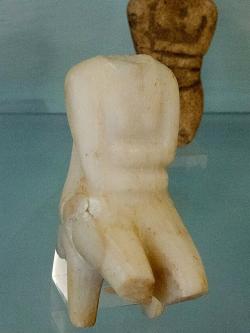 Kykladský idol, žena sedící na trůnu, erodované torzo. Raná doba bronzová, EC II, 2500-2200 před n. l., pohřebiště Aplomata u Chóry. Kredit: Zde, Wikimedia Commons. Licence CC 4.0. Kykladský idol, žena sedící na trůnu, erodované torzo. Raná doba bronzová, EC II, 2500-2200 před n. l., pohřebiště Aplomata u Chóry. Kredit: Zde, Wikimedia Commons. Licence CC 4.0.