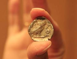 Stříbrná "tetradrachma". Tato je ze sbírky uchovávané v McMasterském muzeu. Mince se datuje do doby po 449 př.nl a její hodnota byla čtyři drachmy. Na jedné straně je bohyně Athena s přílbou, na straně druhé je sova. Nápis AOE znamená "z Athén“.  Kredit: Nasreen Mody, McMaster University,Mississauga, Ontario, Kanada