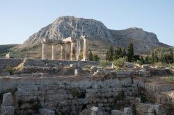 Pohled zpod Apollónova chrámu v Korintu na Akrokorint. Apollónův chrám pochází ještě z řeckých časů, zdálky viditelné stavby na Akrokorintu jsou středověké. Kredit: Zde, Wikimedia Commons. Licence CC 4.0.