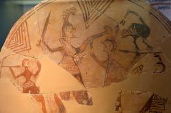 Achilleus bojuje s Amazonkou. Votivní štít z pálené hlíny, průměr 40 cm. Tiryns, Horní citadela, rané 7. století před n. l., tedy výjimečně staré zobrazení! Archeologické muzeum v Naupliu. Kredit: Zde, Wikimedia Commons. Licence CC 4.0.