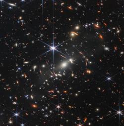 Snímek části prvního hlubokého pole Webbova dalekohledu. Jde o kupu galaxií SMACS 0723. Na snímku je i velký počet velmi vzdálených galaxií přiblížených gravitačním čočkováním. (Zdroj NASA).
