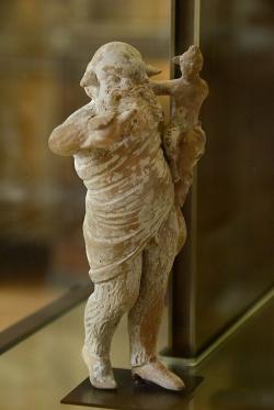 Silén chová malého Dionýsa. Drobná terakota z Tanagry, 300 až 275 před n. l. Louvre, CA 463. Kredit: SpirosK photography, Wikimedia Commons. Licence CC 2.0.