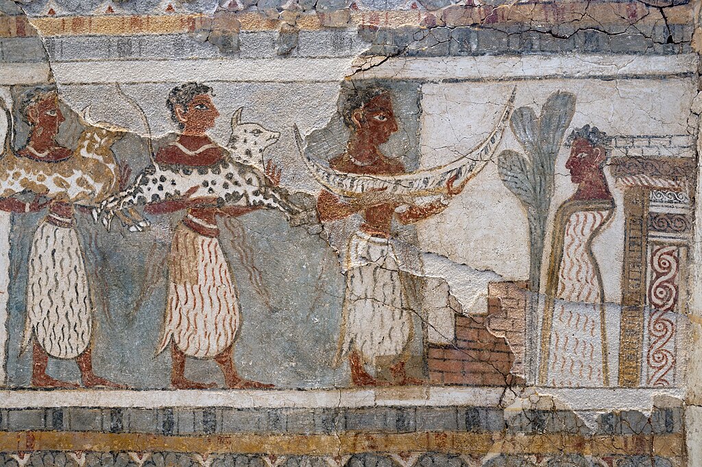 Znakové dary zesnulému, stojícímu vpravo u stromu před hrobkou. Kredit: Zde, Wikimedia Commons. Licence CC 4.0.