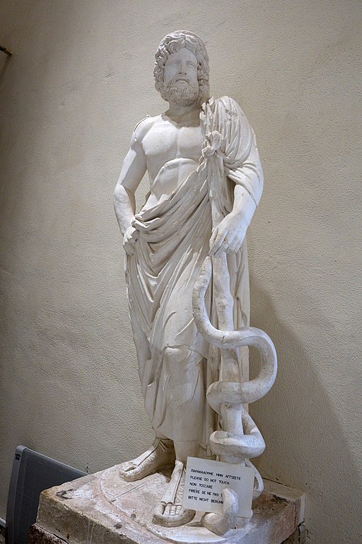 Sádrový odlitek římské kopie pozdně klasické sochy Asklepia, 160 n. l. Typus sochy tohoto boha. Nalezeno v komplexu Asklépiovy lázně a knihovny. Archeologické muzeum v Epidauru, EAM 263. Kredit: Zde, Wikimedia Commons.