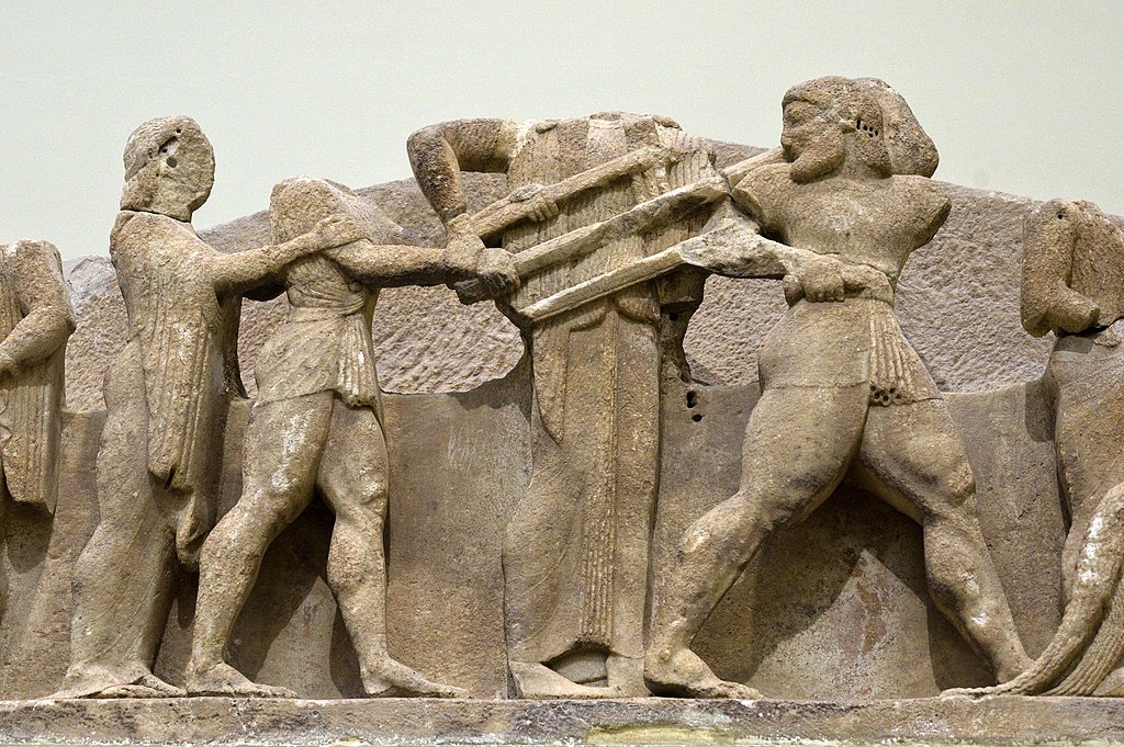 Héraklés se přetahuje s Apollónem o trojnožku. Východní průčelí pokladnice Sifnijských v Delfách, 525 před n. l. Archeologické muzeum v Delfách. Kredit: Zde, Wikimedia Commons. Licence CC 4.0.