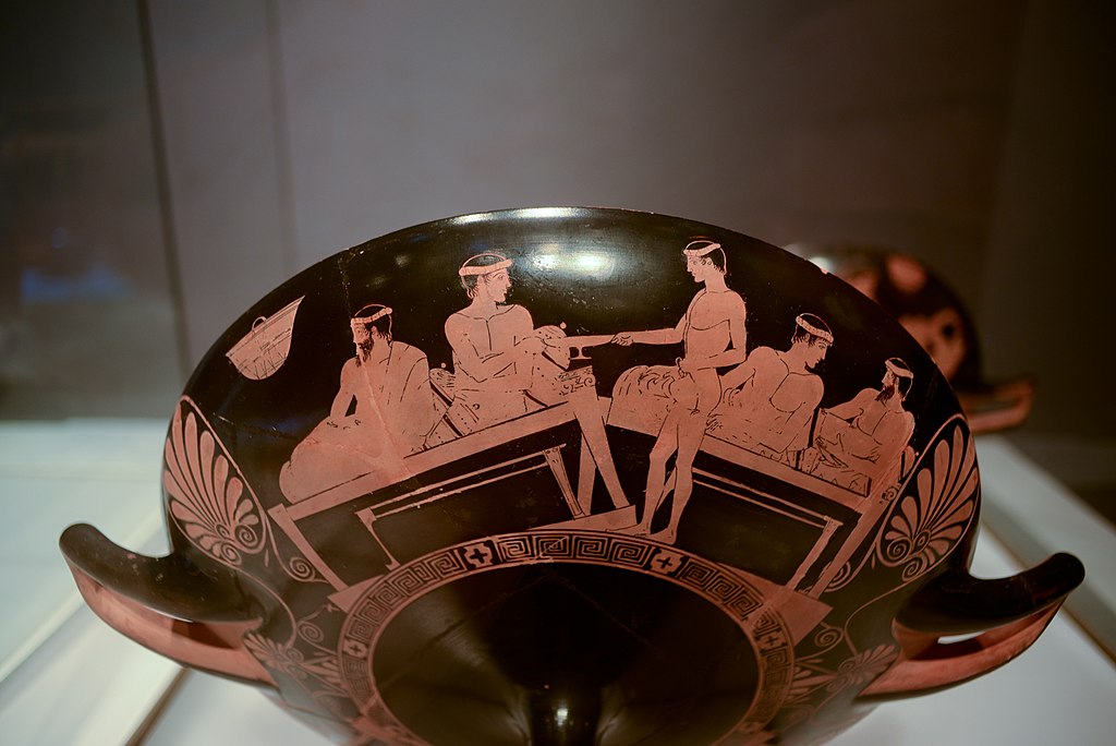 Červenofigurový kylix (picí miska), symposion, 460-450 před n.l. Louvre G 467. Kredit: Ruthven, Wikimedia Commons.